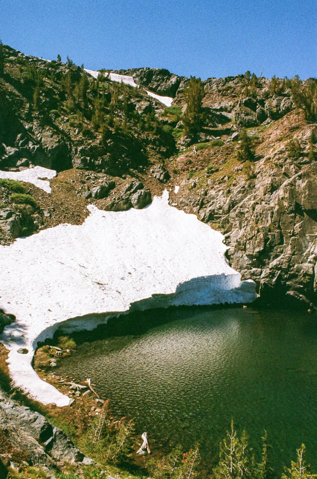 A snowbank slowly melts into Ruby Lake.
